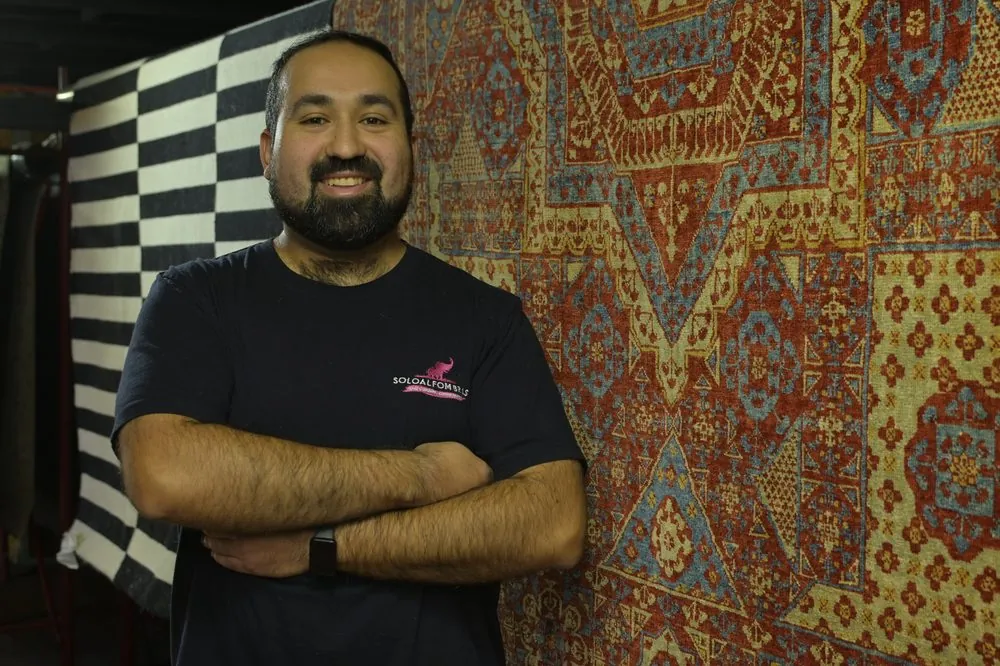 Aspirando una alfombra persa colgada con máquina industrial