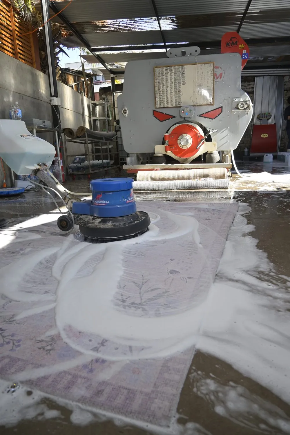 Máquina lavando una alfombra con espuma